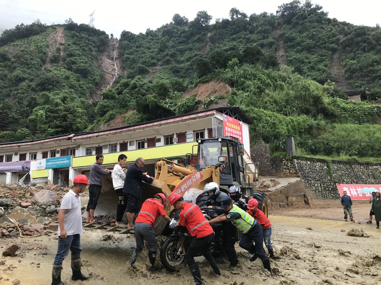 8月18日，搶險(xiǎn)人員與民警幫助被困群眾的摩托車通過(guò)涉水路面.jpg